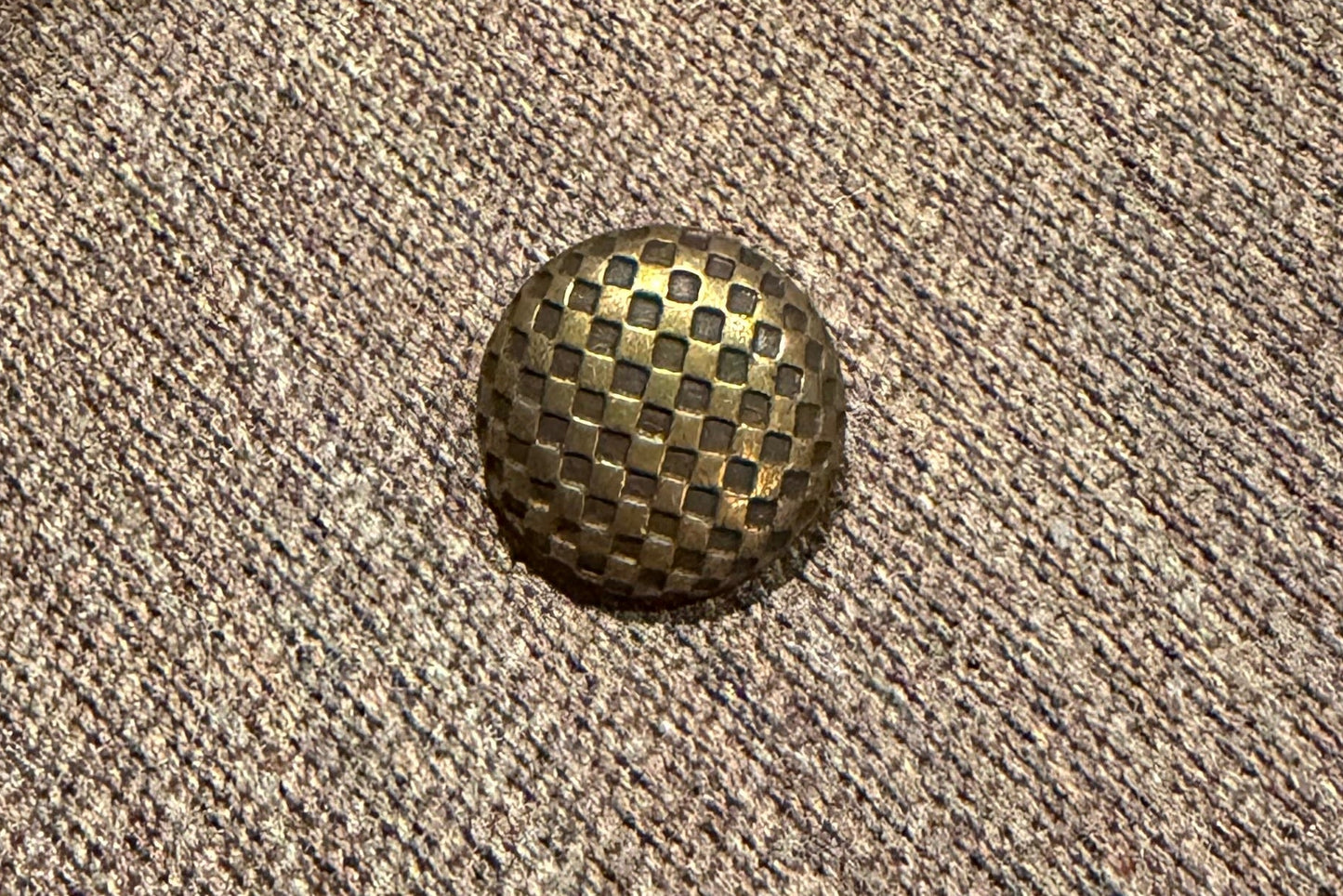 Metallic button on a textured fabric surface