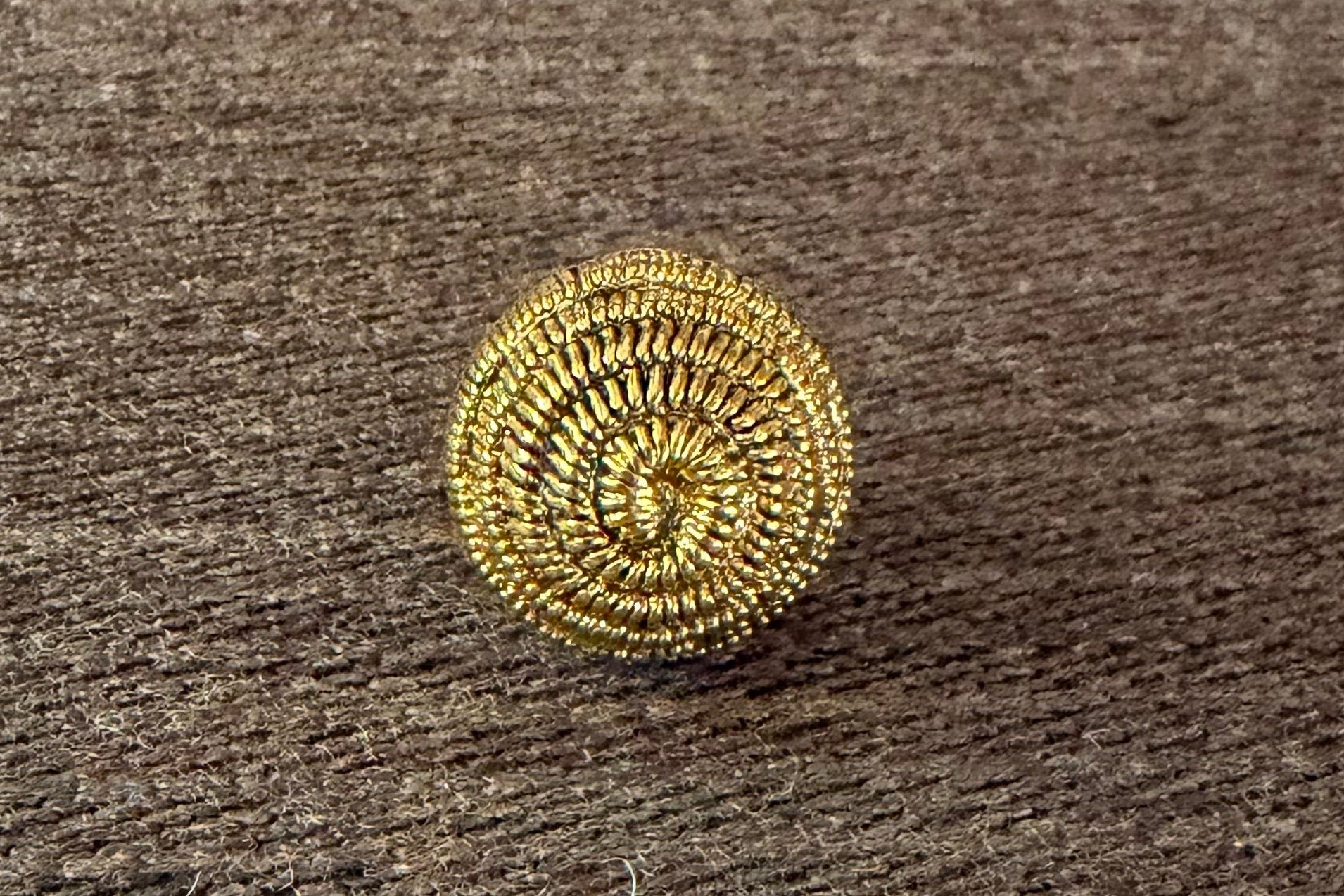 Gold decorative button on a textured surface