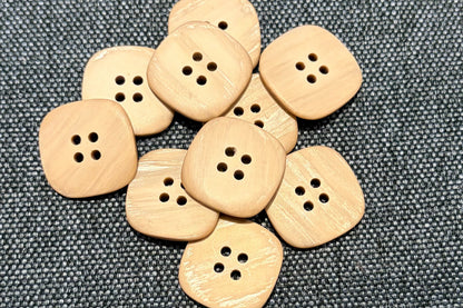Tan buttons on a gray fabric background