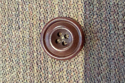 Brown button on a textured fabric background