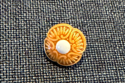 Decorative button with floral pattern on a textured fabric background