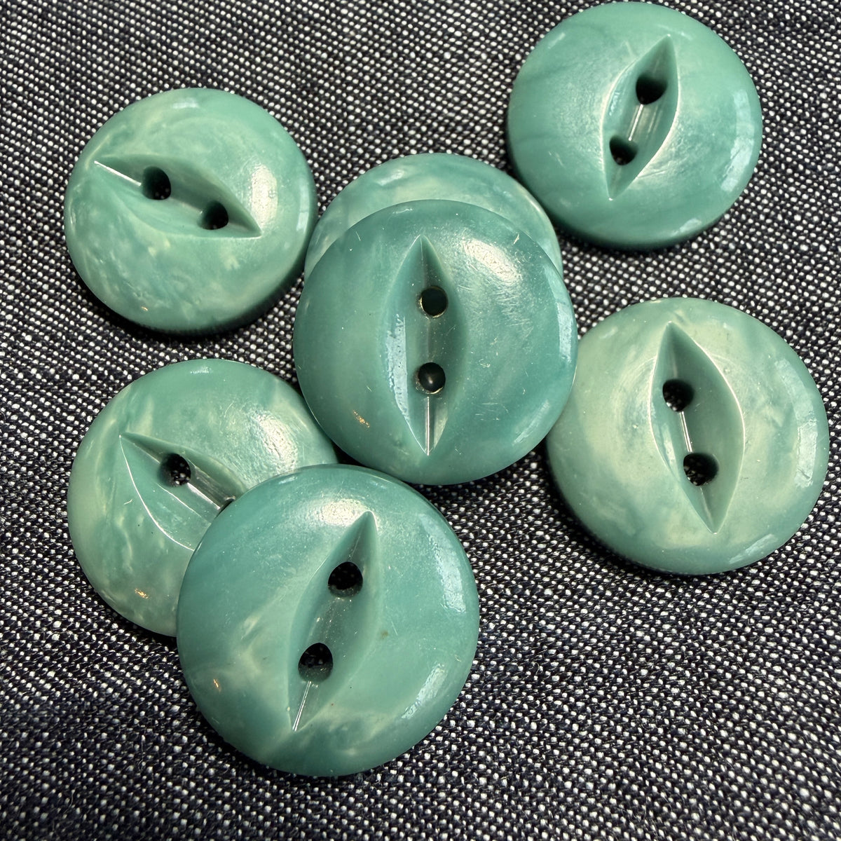 Detail of a natural teal casein fisheye button.