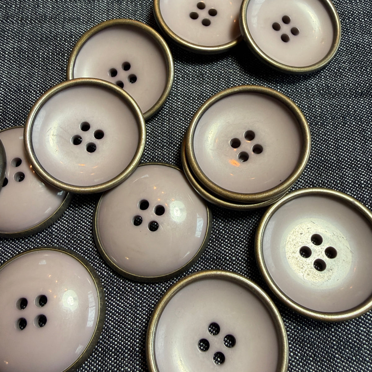 Large mauve acrylic button with a metal rim and a deep concave centre.
