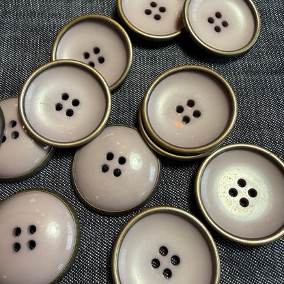 Large mauve acrylic button with a metal rim and a deep concave centre.