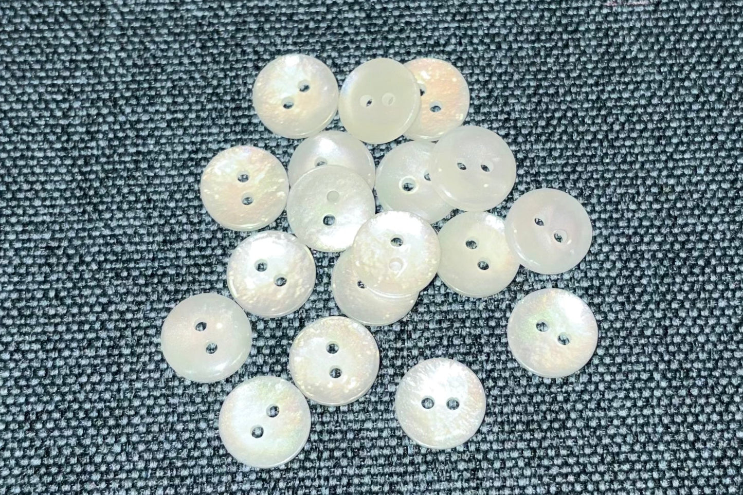 White buttons on a textured gray fabric background
