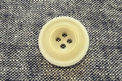 White button on a textured gray fabric background
