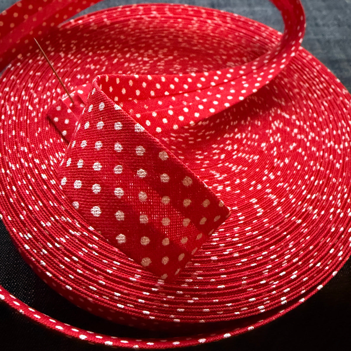 Red polka dot cotton bias tape on the roll