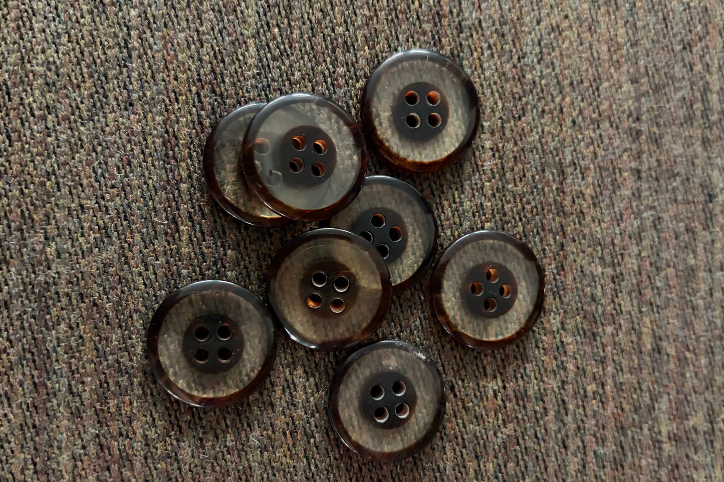 Brown and clear buttons on a textured fabric surface