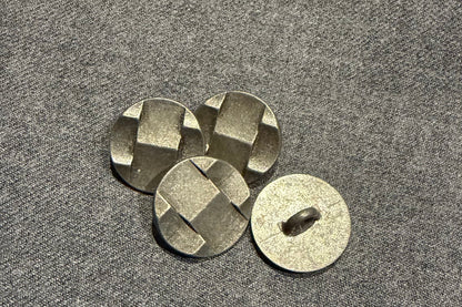 Four metallic buttons on a textured gray surface