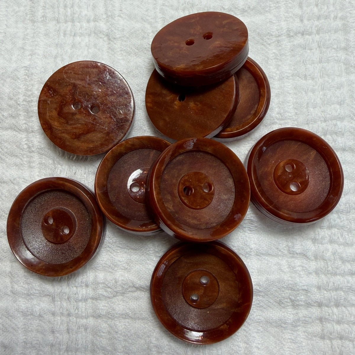 Natural brown casein two-hole buttons in 14 mm and 22 mm.