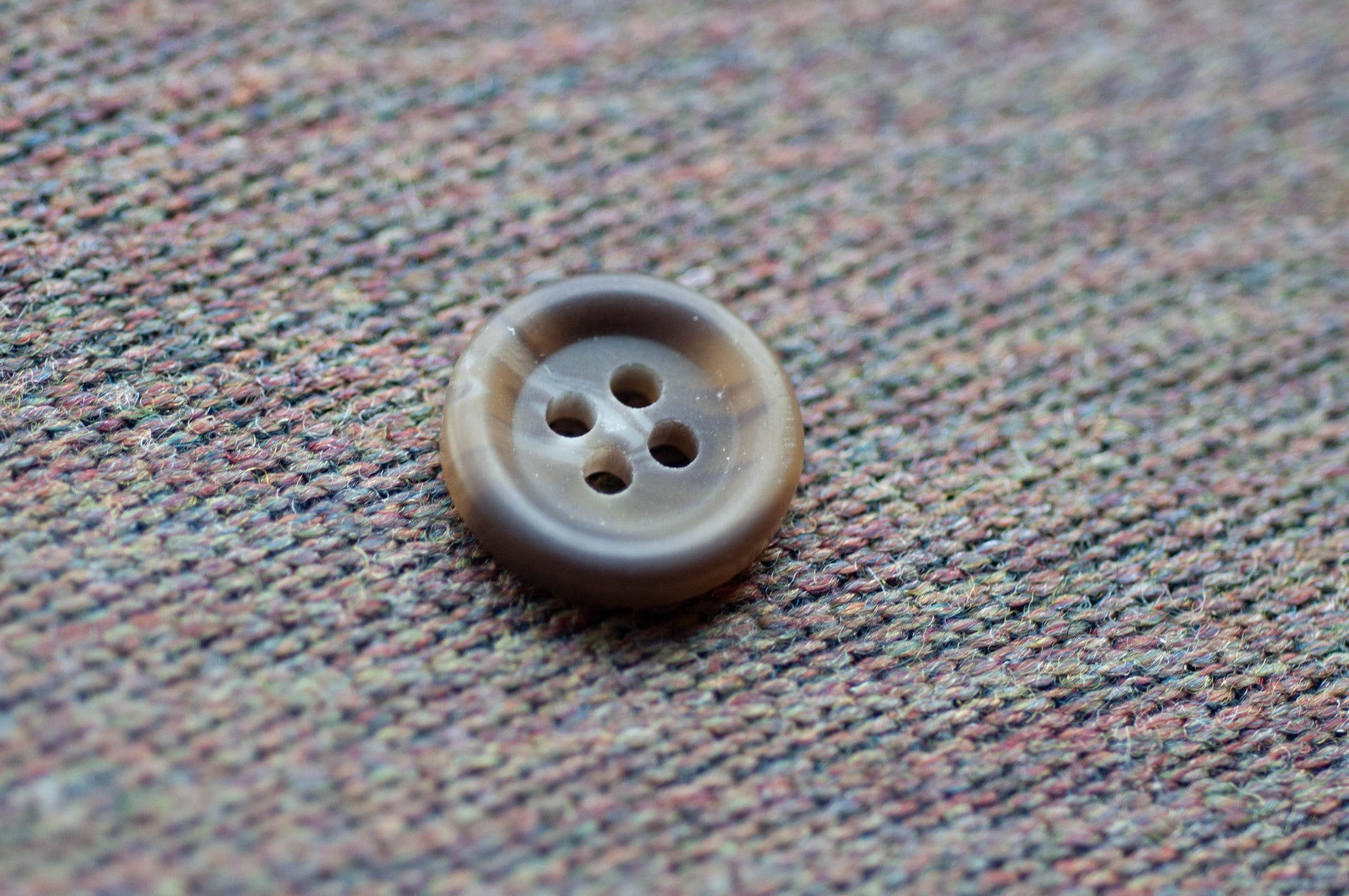 Brown button on a textured fabric background
