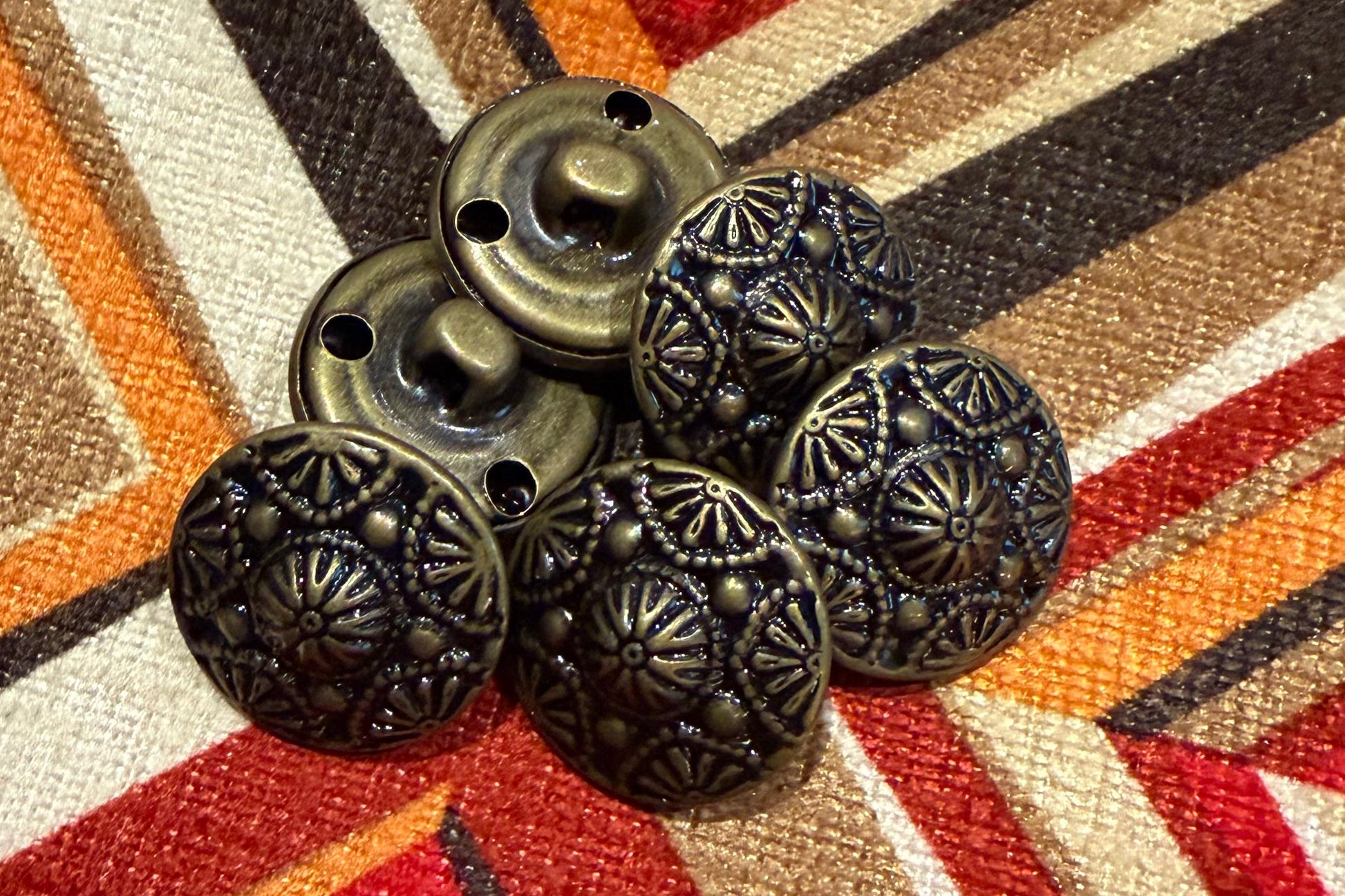 Decorative metal buttons 
on a patterned fabric background