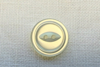 White button on a textured white  fabric background