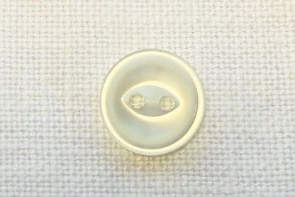 Small white button with on a textured fabric background