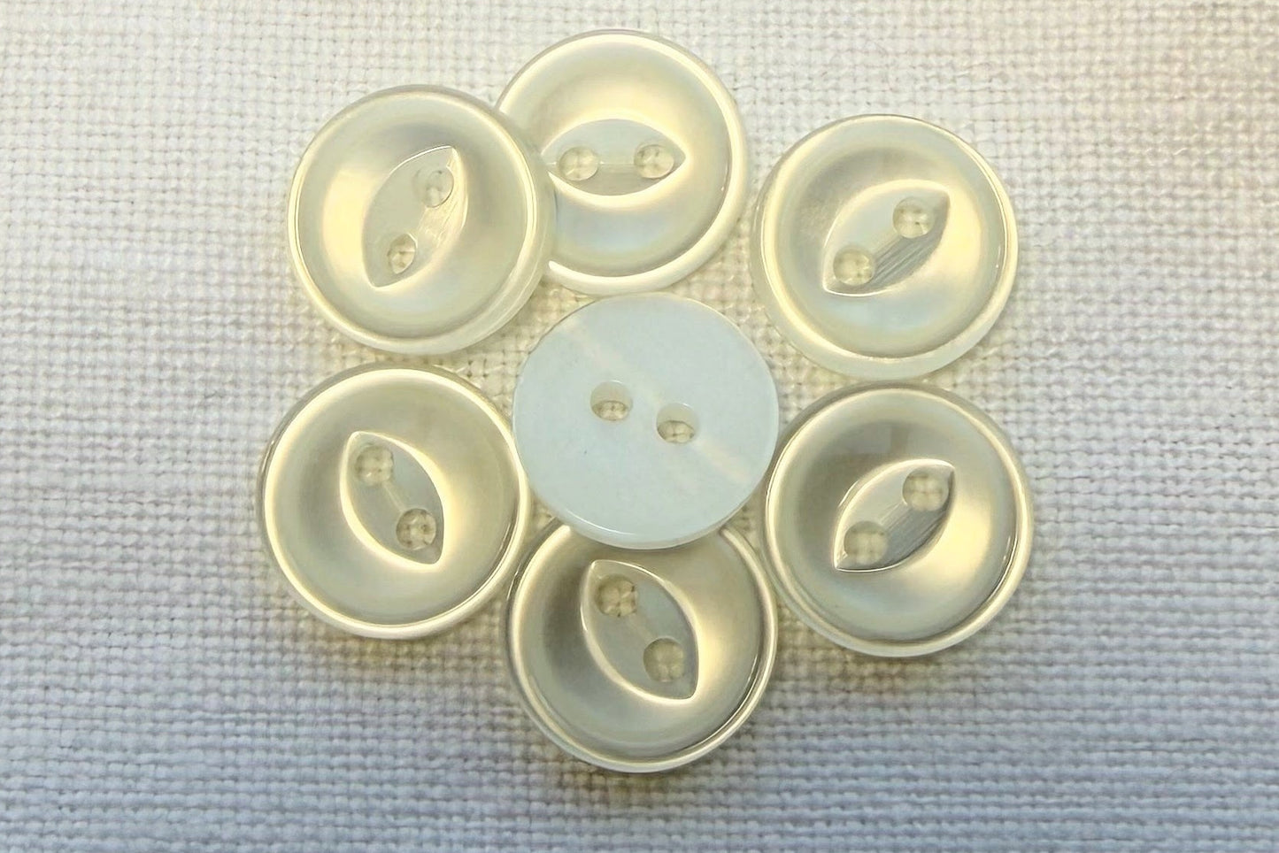 White buttons on a textured fabric background