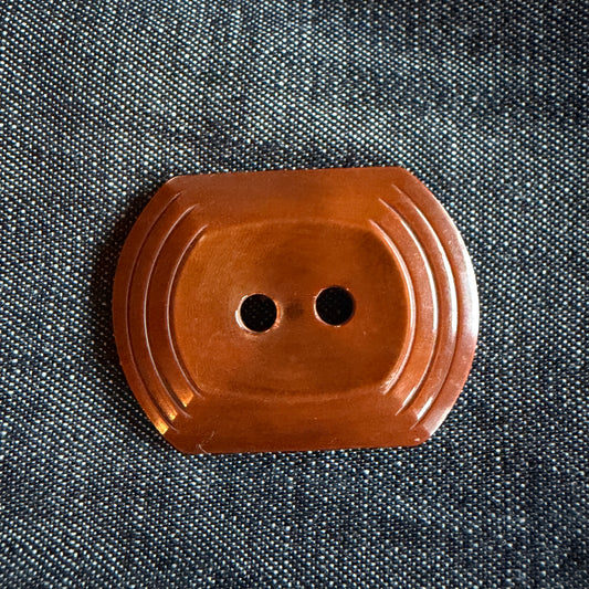 Natural brown oblong casein buttons with a tiered edge, 30 x 38 mm, handmade in Argentina.