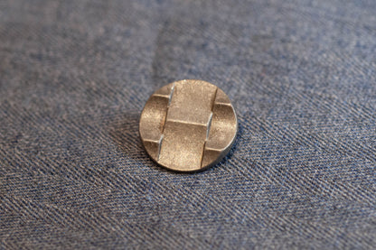 Silver button on a textured gray fabric background