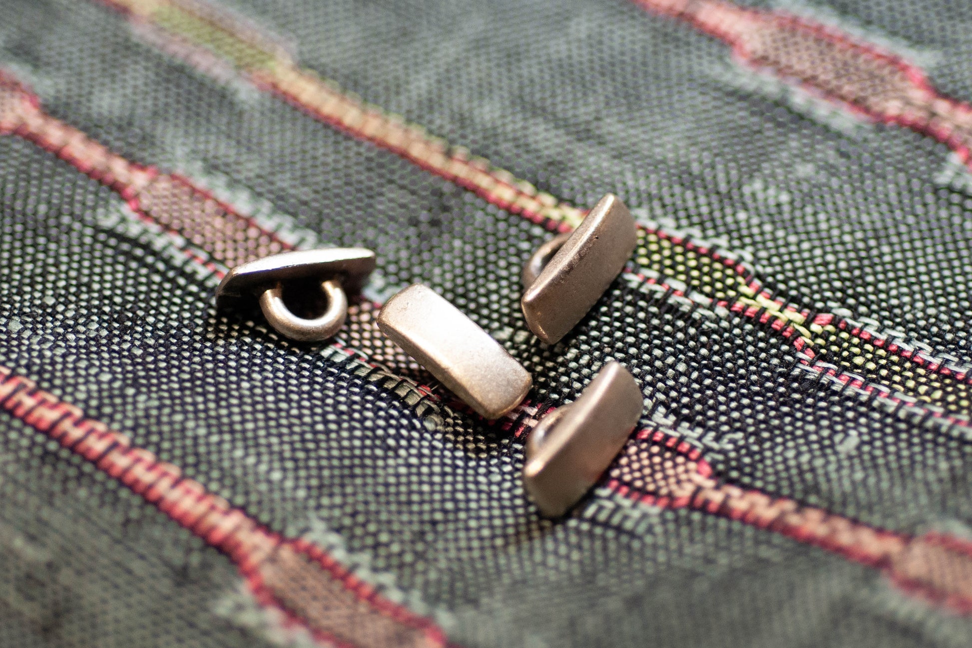 Close-up of metal buttons on a textured fabric background
