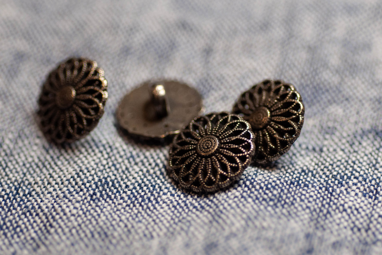 Dark silver decorative buttons on a denim fabric background